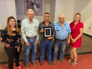 2021-2022 Employee of the Year Alvaro Monteverde holding a plaque while surrounded by others.