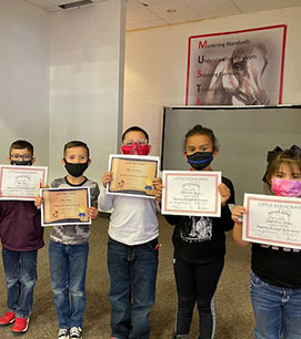 Four students holding their award certificates
