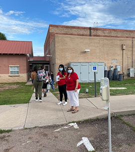 People standing by the side of the school building