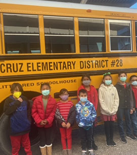 Students smiling next to the bus